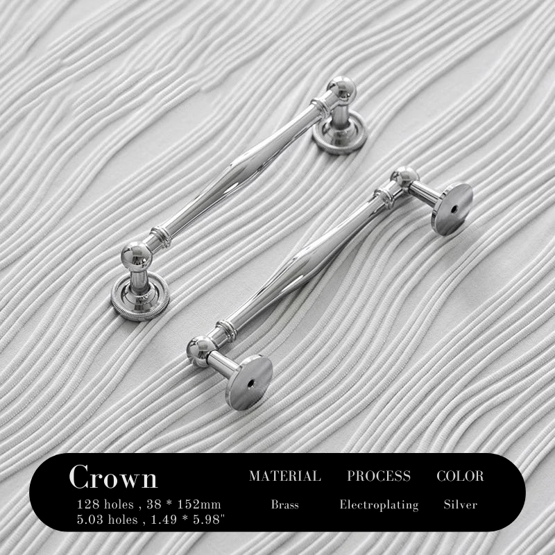 Silver crown-shaped earrings on a textured white background