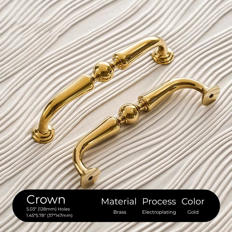 Two gold cabinet handles on a textured beige background