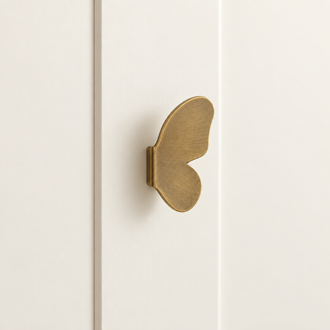 Brushed Brass Butterfly Cabinet Knob — Decorative Accent Design on warm ivory stone