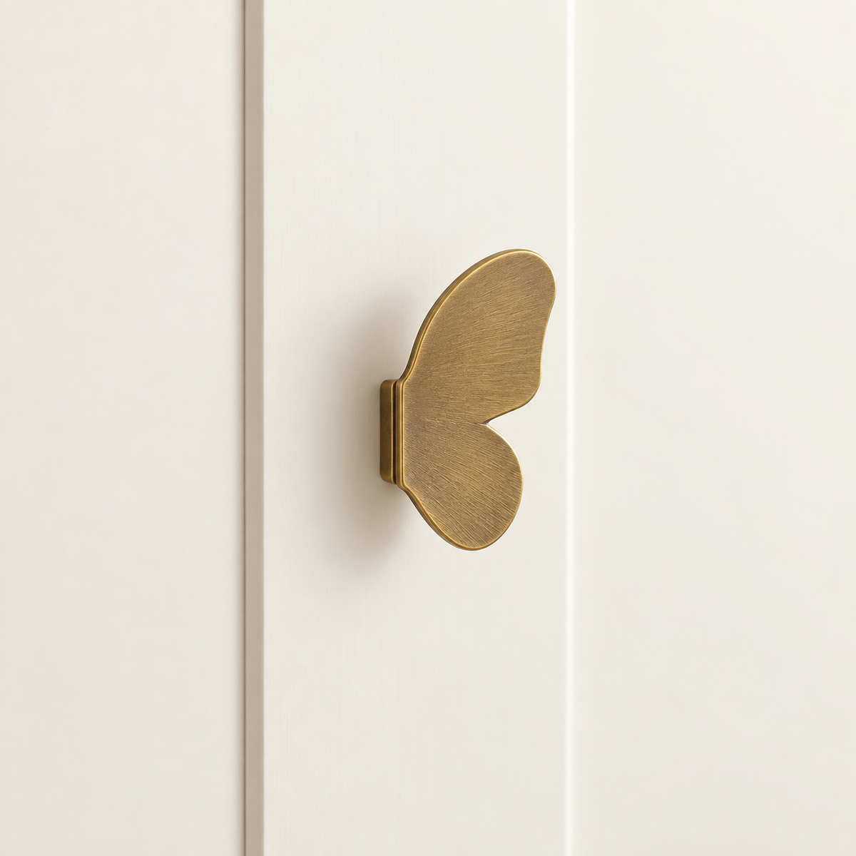 Brushed Brass Butterfly Cabinet Knob — Decorative Accent Design installed on warm ivory cabinetry