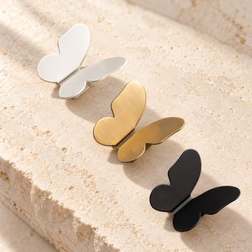 Brushed Brass Butterfly Cabinet Knob — Decorative Accent Design on warm ivory stone