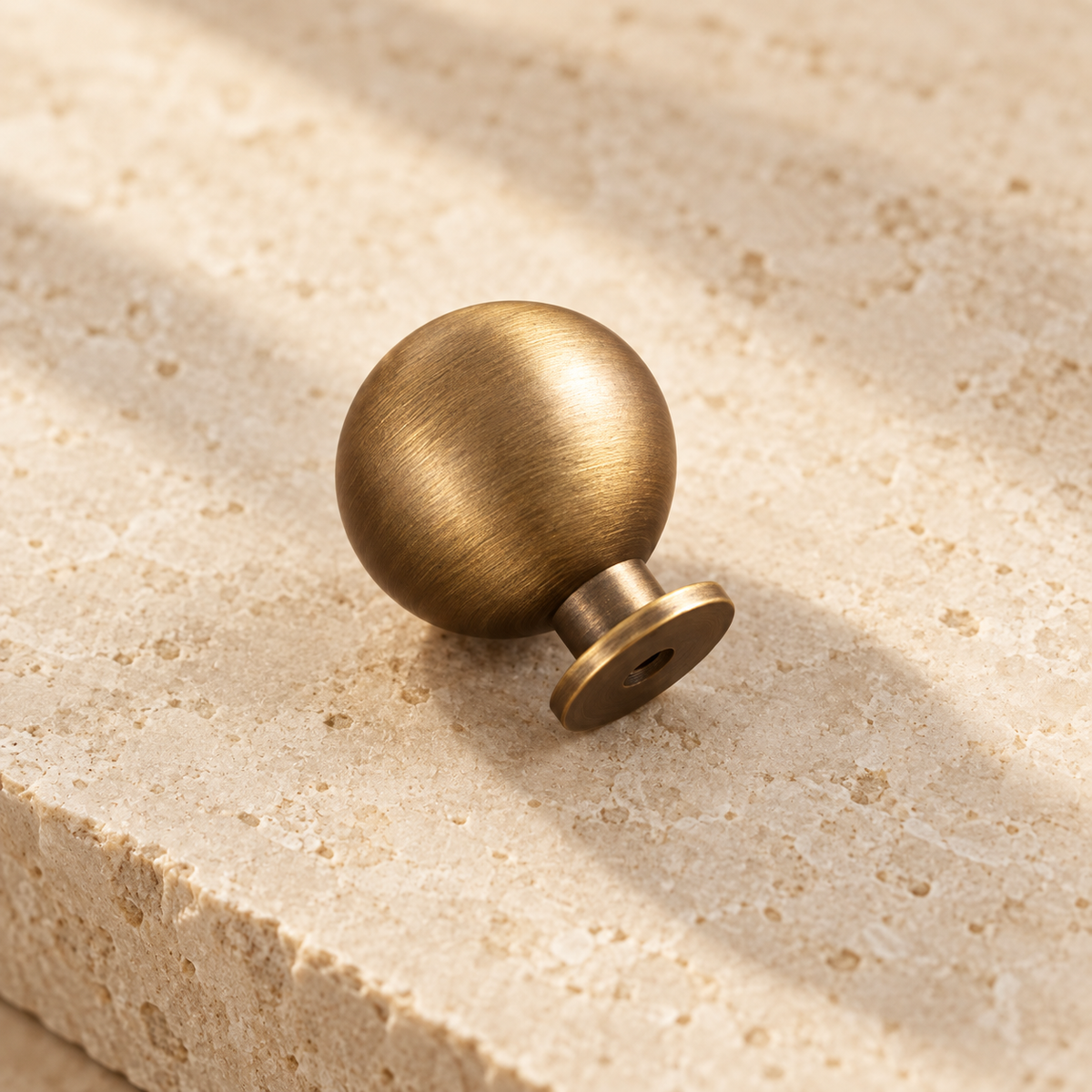 Antique Brass Round Cabinet Knobs — Retro Design on warm ivory stone