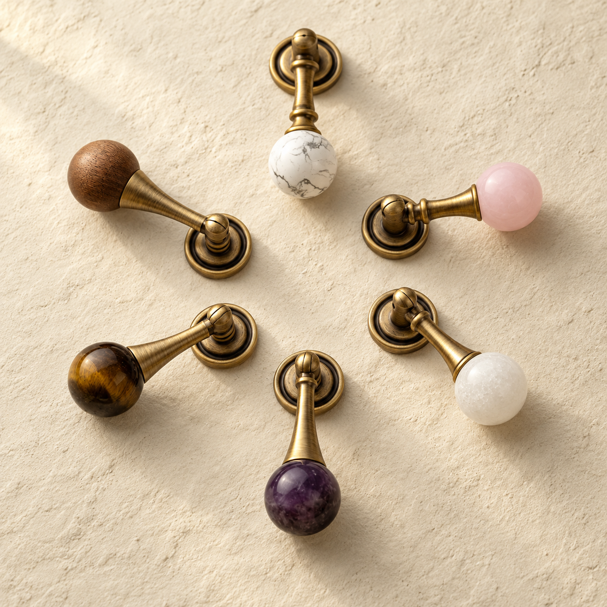 Antique Brass Drop Pulls with Stone & Wood Inlays on a warm ivory background