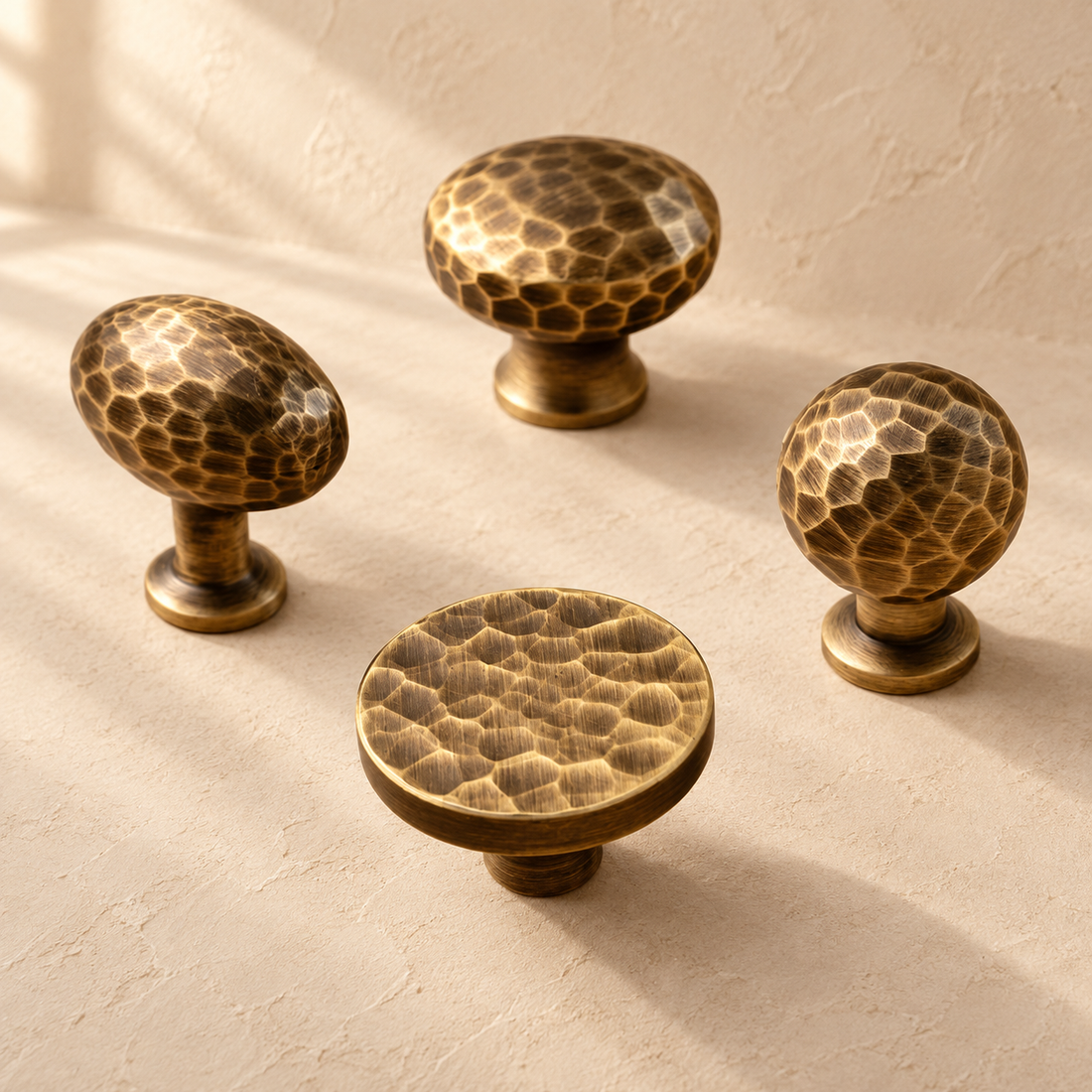 Hand-Hammered Solid Brass Cabinet Knobs — Antique Brass on a warm ivory background