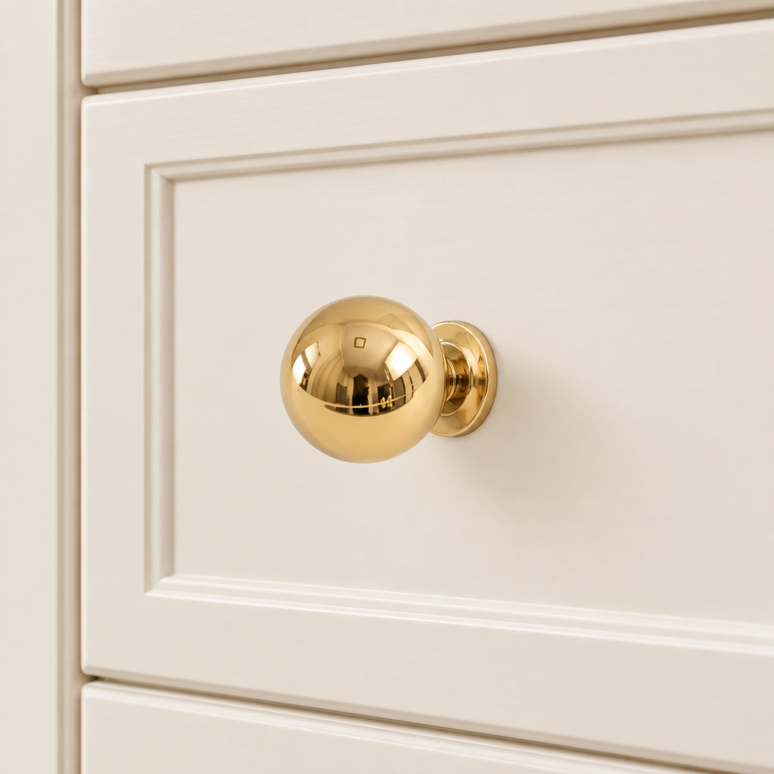 Ball Cabinet Knobs — Polished Brass on warm ivory stone