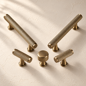 Diamond-Knurled Solid Brass Cabinet Pulls & Knobs — Antique Brass on a warm ivory background