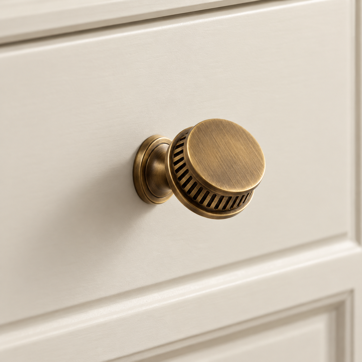 Antique Brass Spiral Ribbed Solid Brass Cabinet Pulls & Knobs installed on warm ivory cabinetry