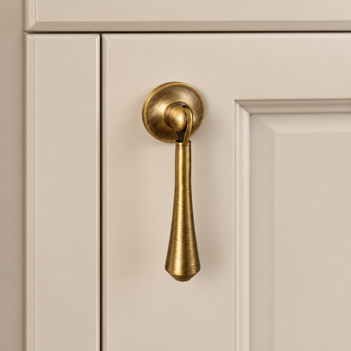 Brushed Antique Brass Cabinet Handle & Knob — Tear Drop Design installed on warm ivory cabinetry