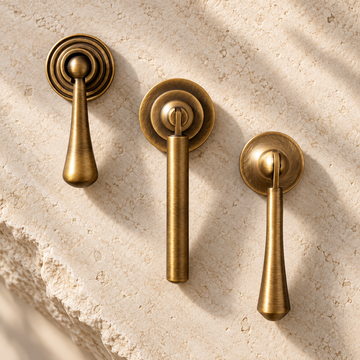 Brushed Antique Brass Cabinet Handle & Knob — Tear Drop Design on warm ivory stone