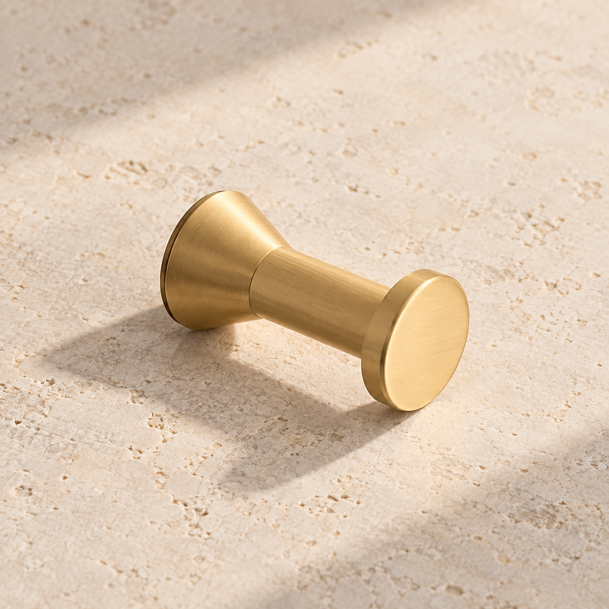 Brass Wall Hook — Brushed Brass Finish on warm ivory stone