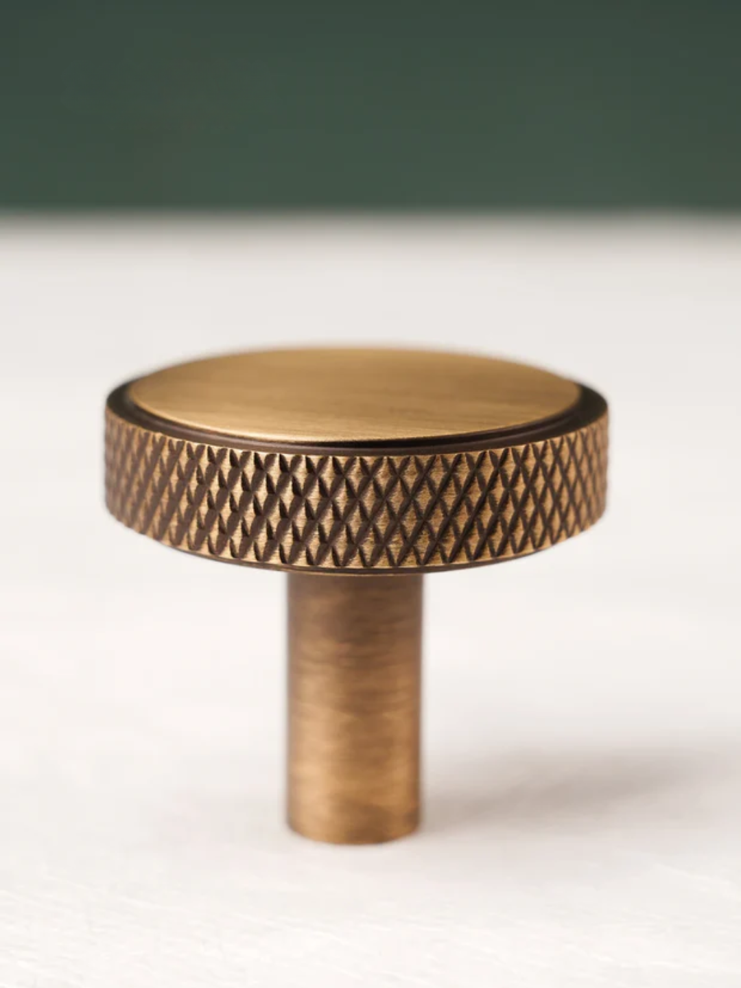 Bronze-colored knob with textured surface on a white background