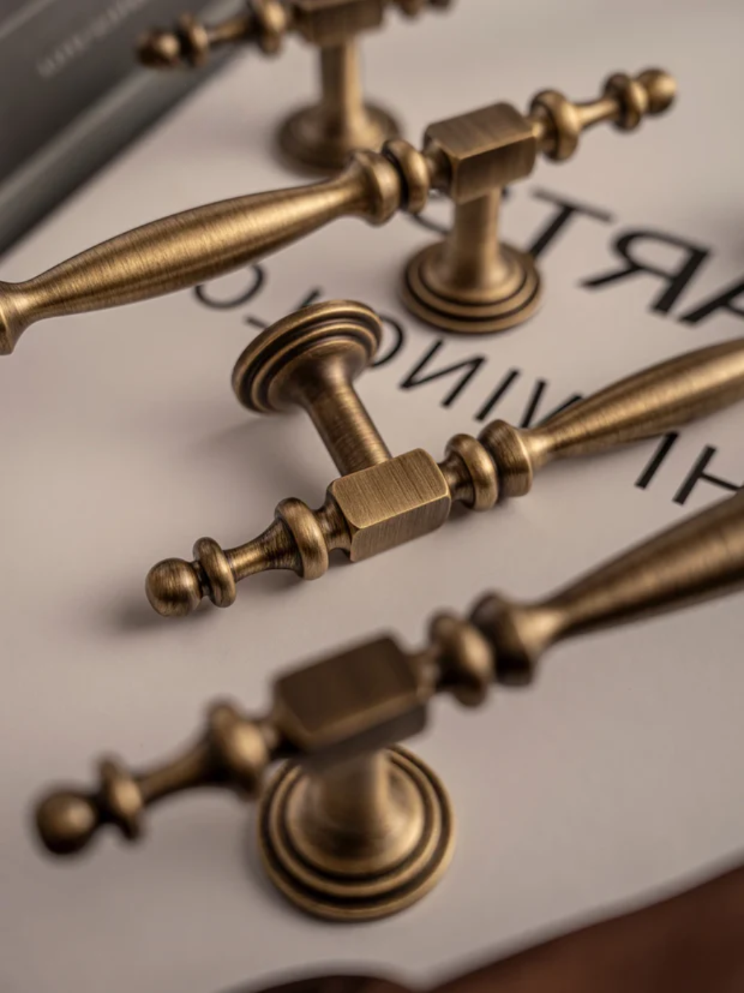 Close-up of bronze door handles on a white surface with text.