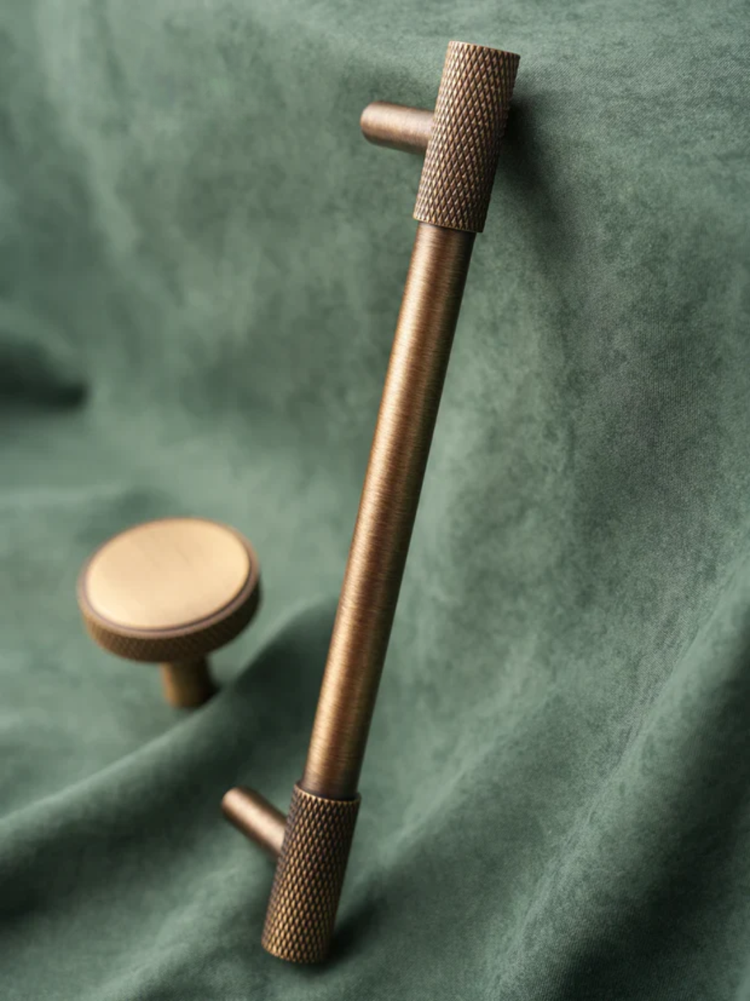 Bronze door handle on a green fabric background