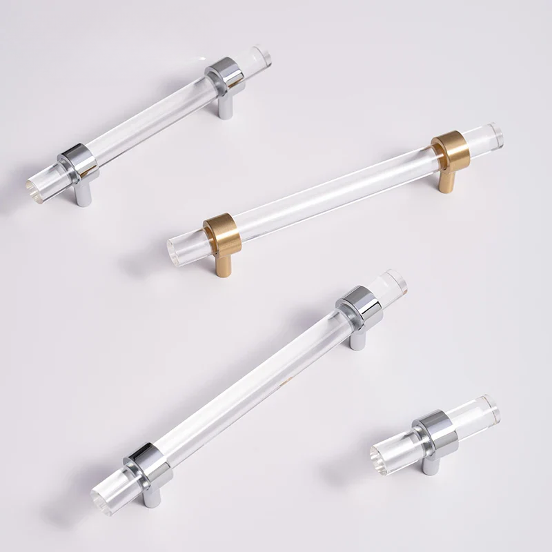 Clear acrylic cabinet handles with metallic ends on a light gray background