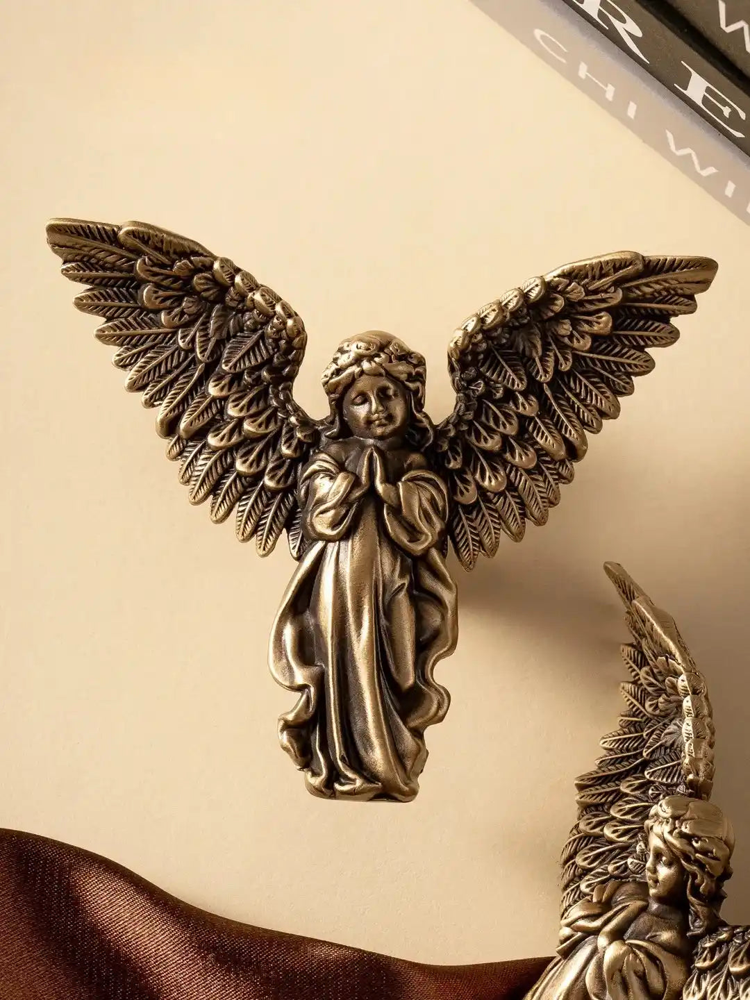 Bronze angel figurine on a beige background