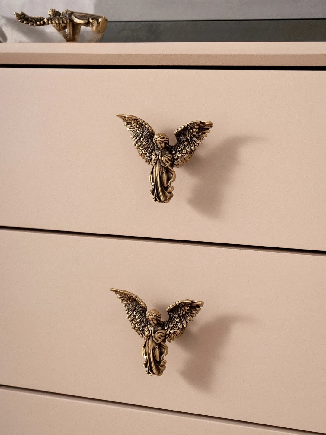 Beige dresser with gold angel-shaped handles