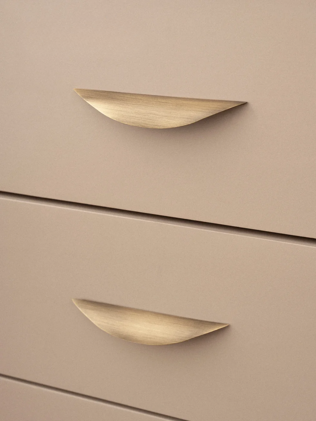 Beige drawers with gold handles on a beige background