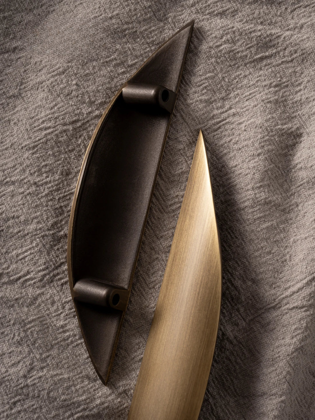 Decorative wall hook with black and gold design on a textured gray background