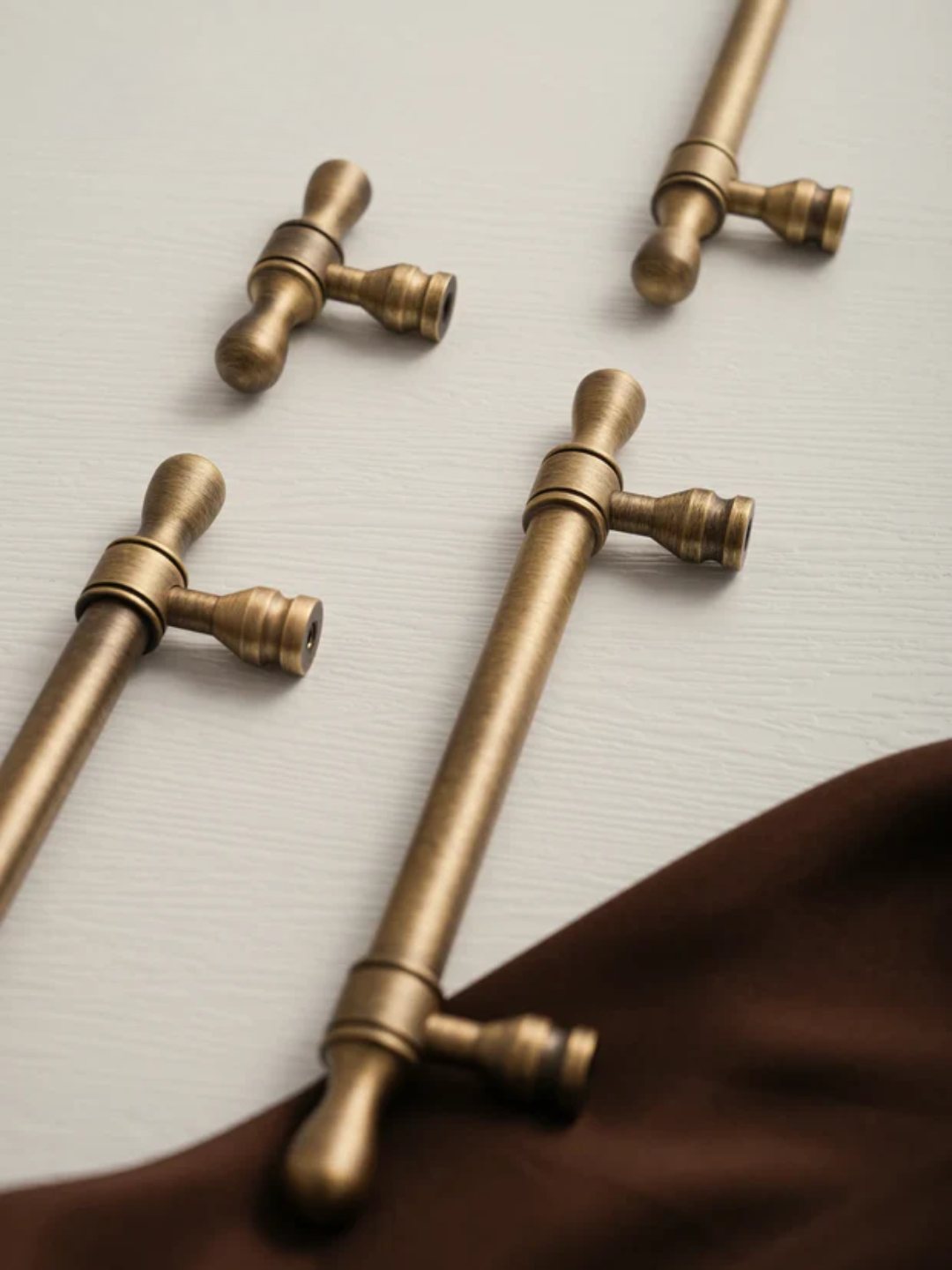 Set of bronze kitchen faucet handles on a neutral background