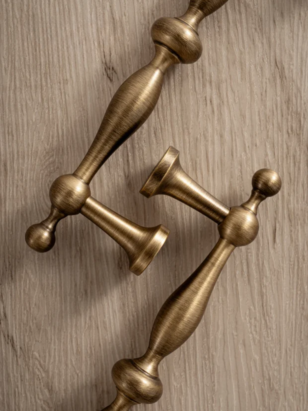 Close-up of decorative bronze door handles on a wooden surface