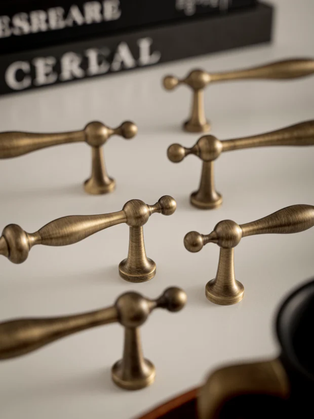 Set of brass handles on a white surface with a blurred background
