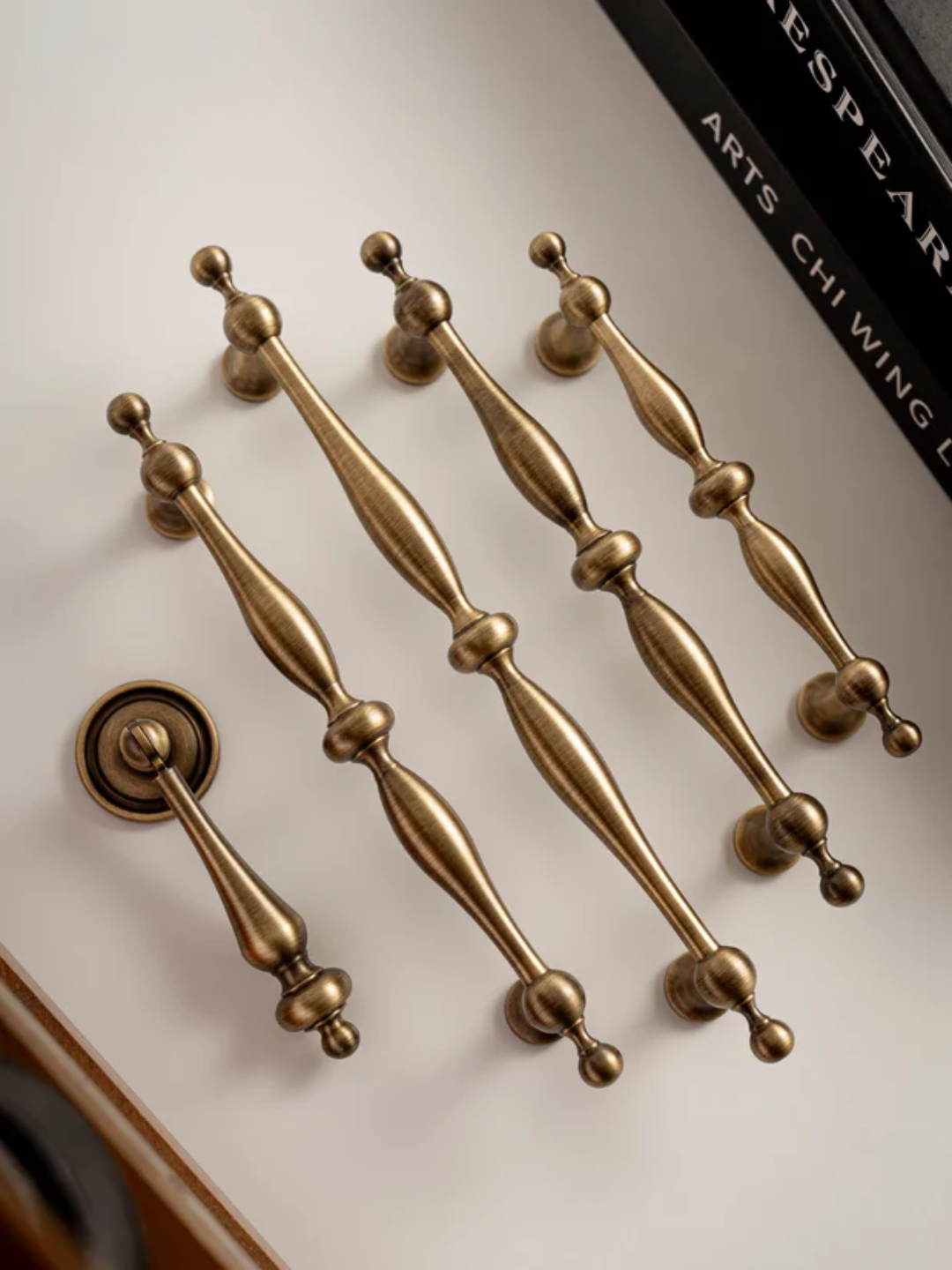 Set of gold door handles on a white surface with a blurred background