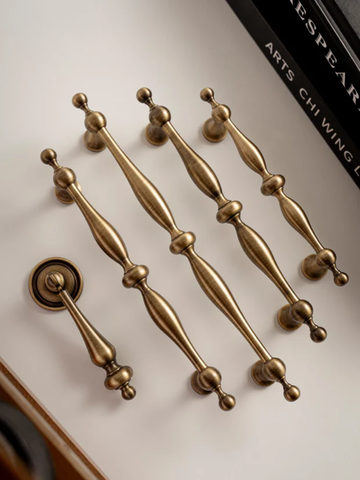 Set of gold door handles on a white surface with a blurred background