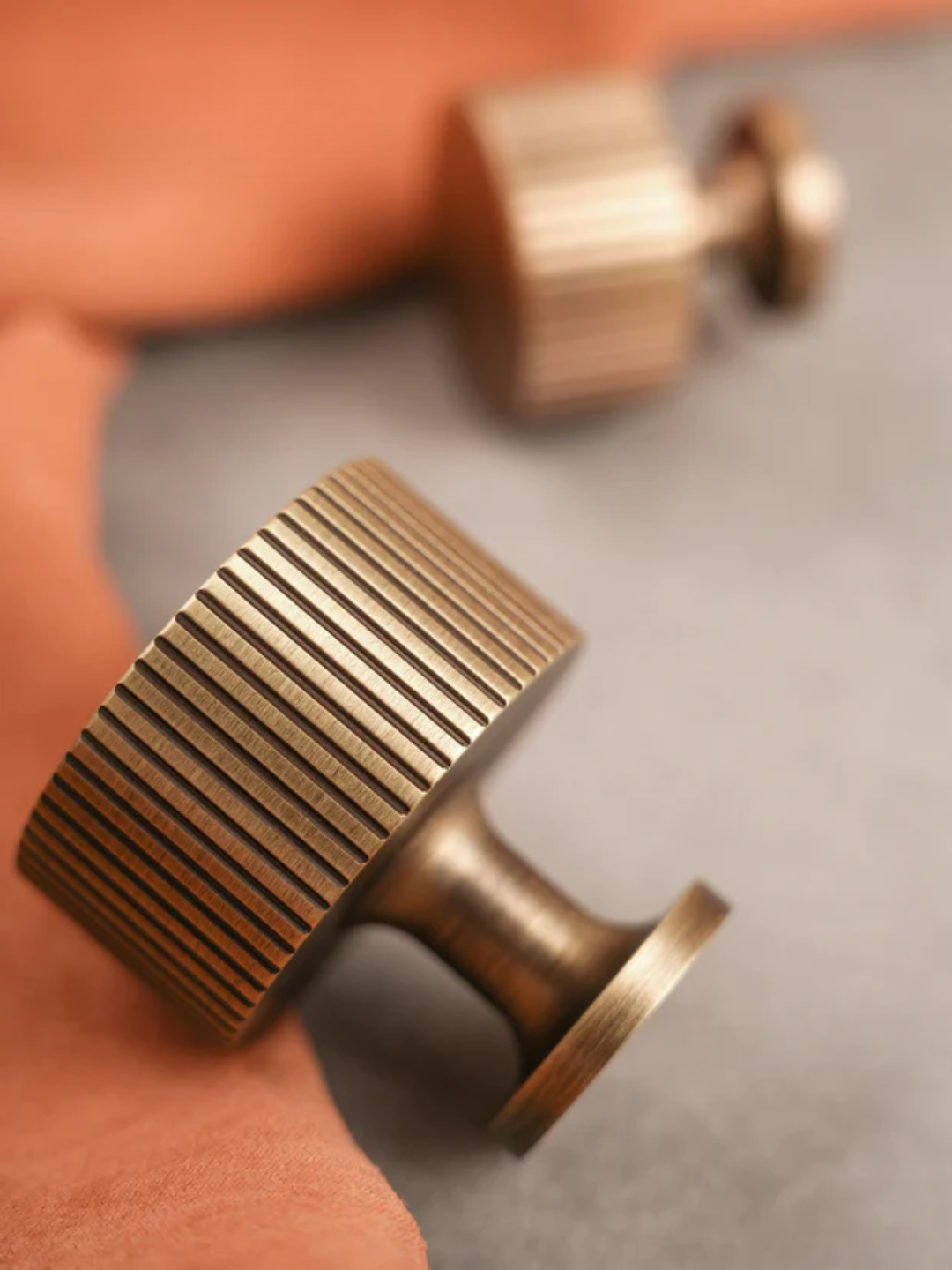 Close-up of a bronze cabinet knob on a wooden surface