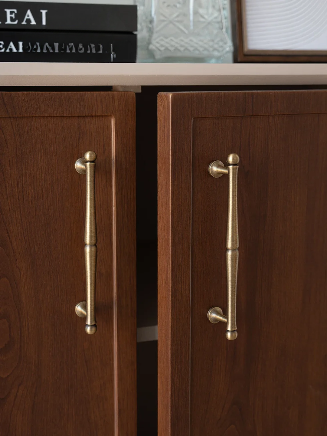 Wooden cabinet with brass handles on a neutral background
