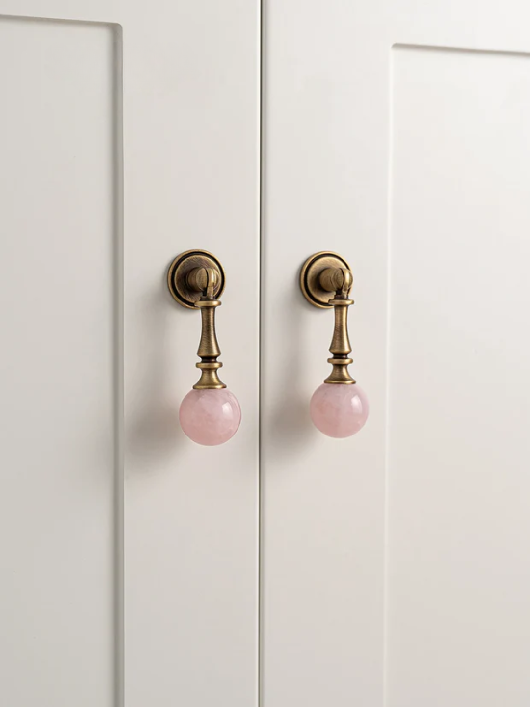 Cabinet doors with pink knobs on a white background
