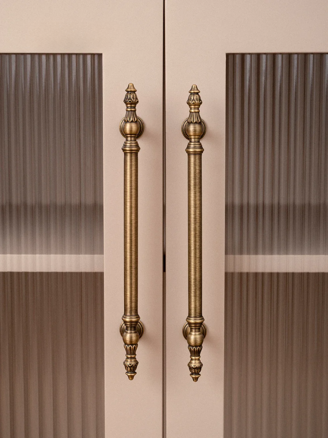 Decorative bronze handles on a door with a striped pattern