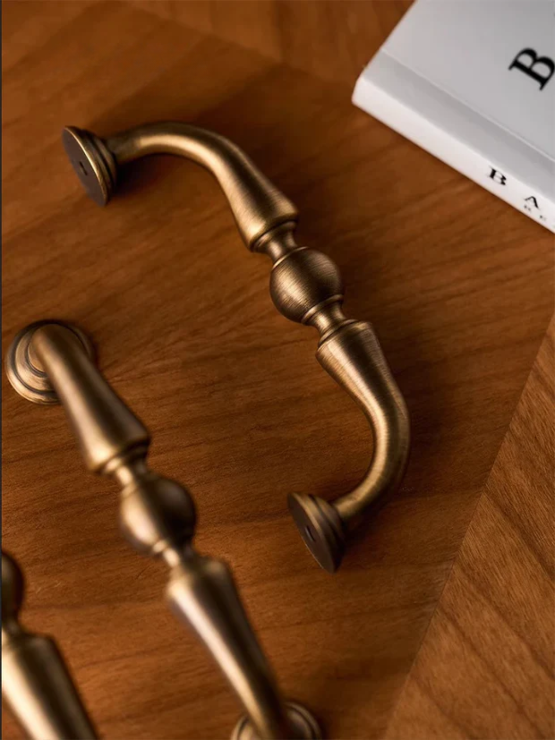 Brass cabinet handles on a wooden surface.