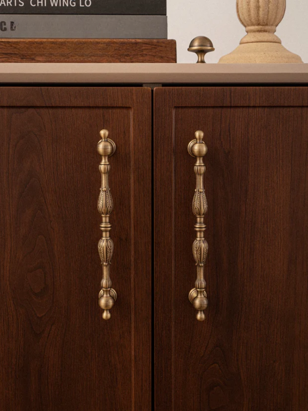 Wooden cabinet with brass handles on a neutral background