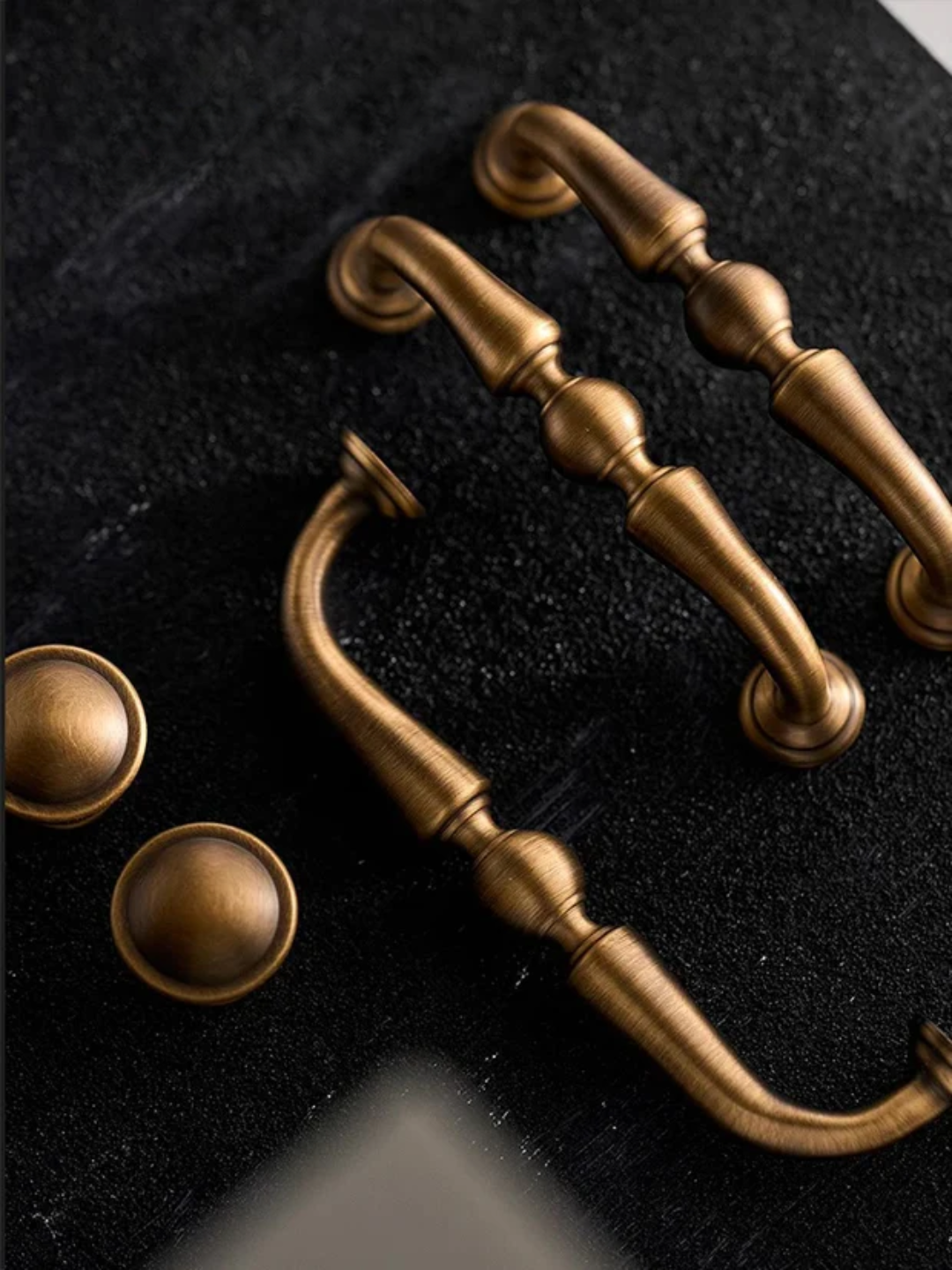 Bronze handles on a black surface