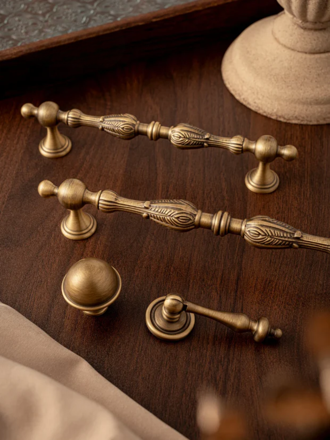 Set of vintage-style brass cabinet handles on a wooden surface