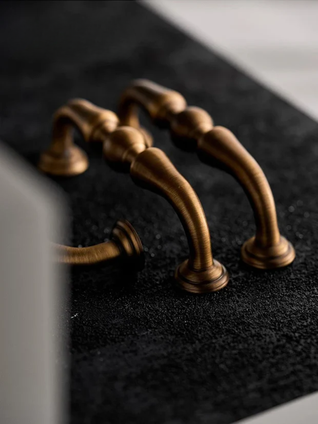 Bronze handles on a black surface
