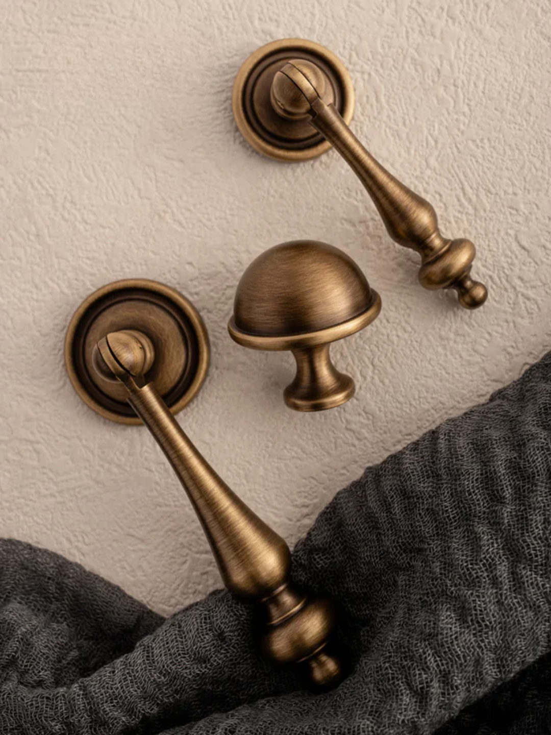 Brass door handles and knobs on a textured wall with 'Santaya' branding.