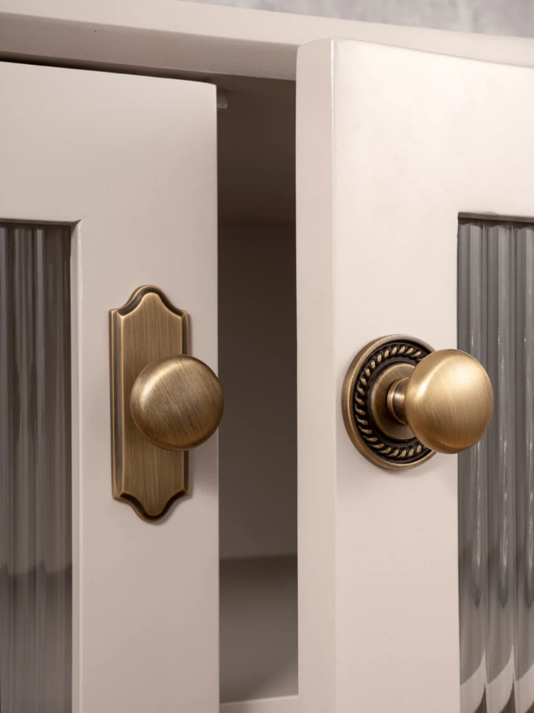 Close-up of a white cabinet with brass door handles