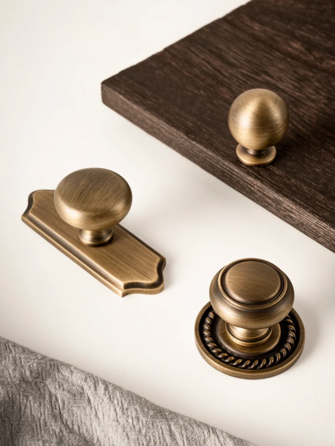 Bronze cabinet knobs on a wooden and white background