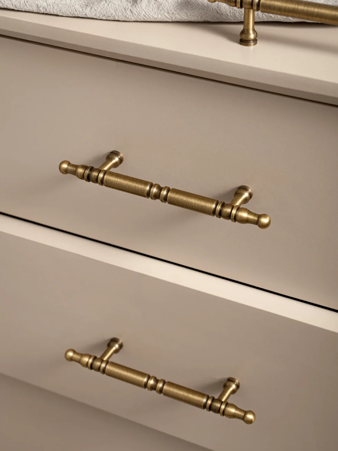 Close-up of beige drawers with gold handles