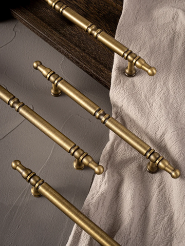 Set of gold cabinet handles on a neutral background