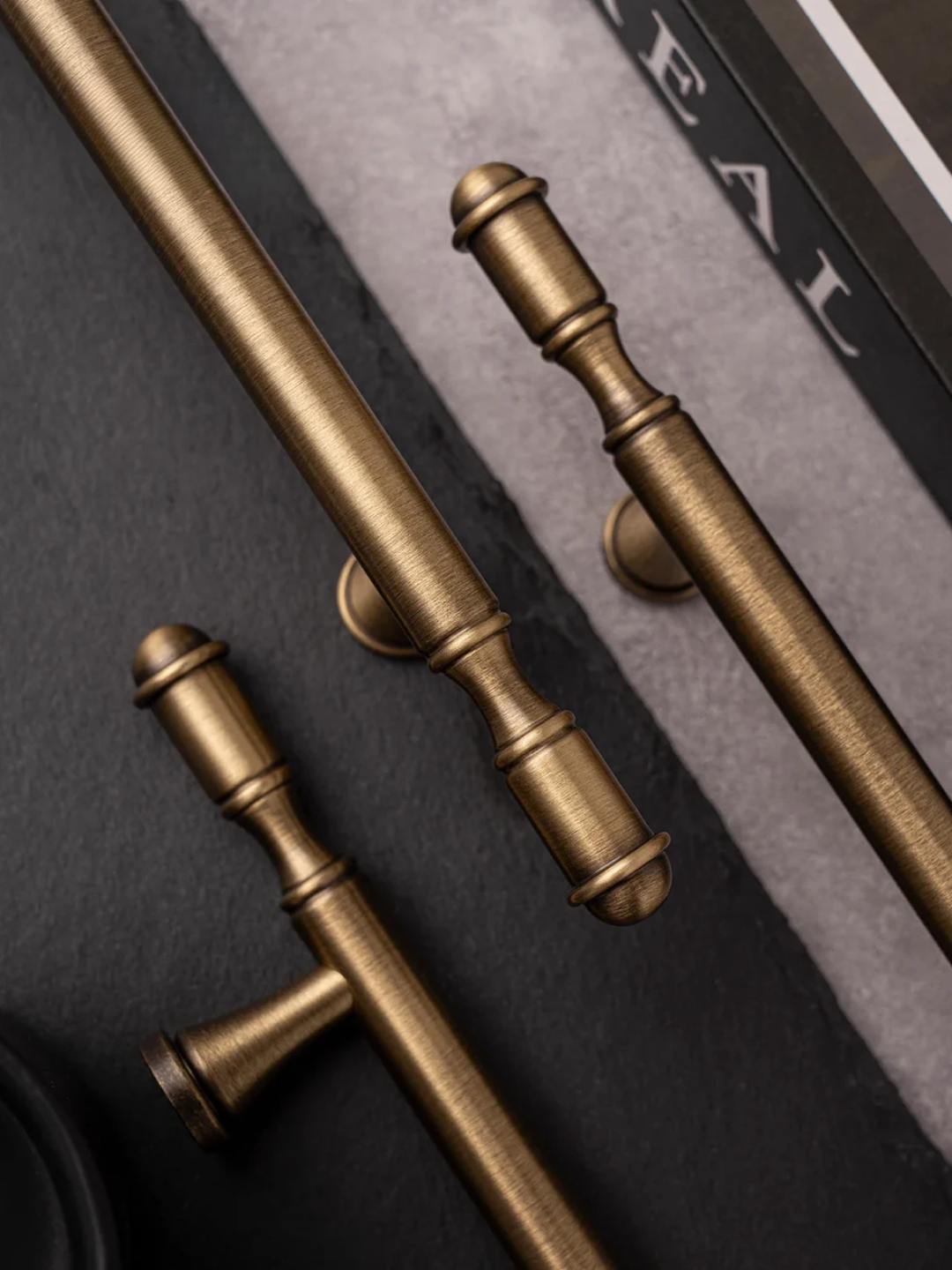 Close-up of gold cabinet handles on a dark surface