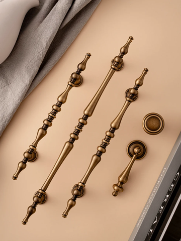 Set of bronze door handles on a beige surface