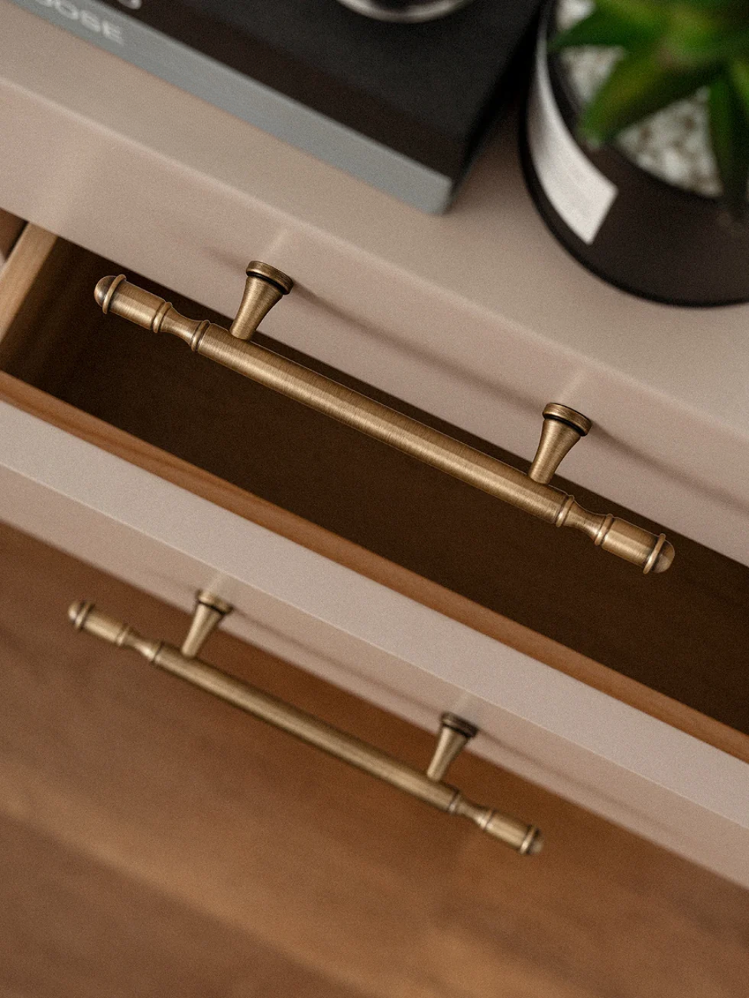 Close-up of a drawer with gold handles on a white surface, featuring the Santaya brand.
