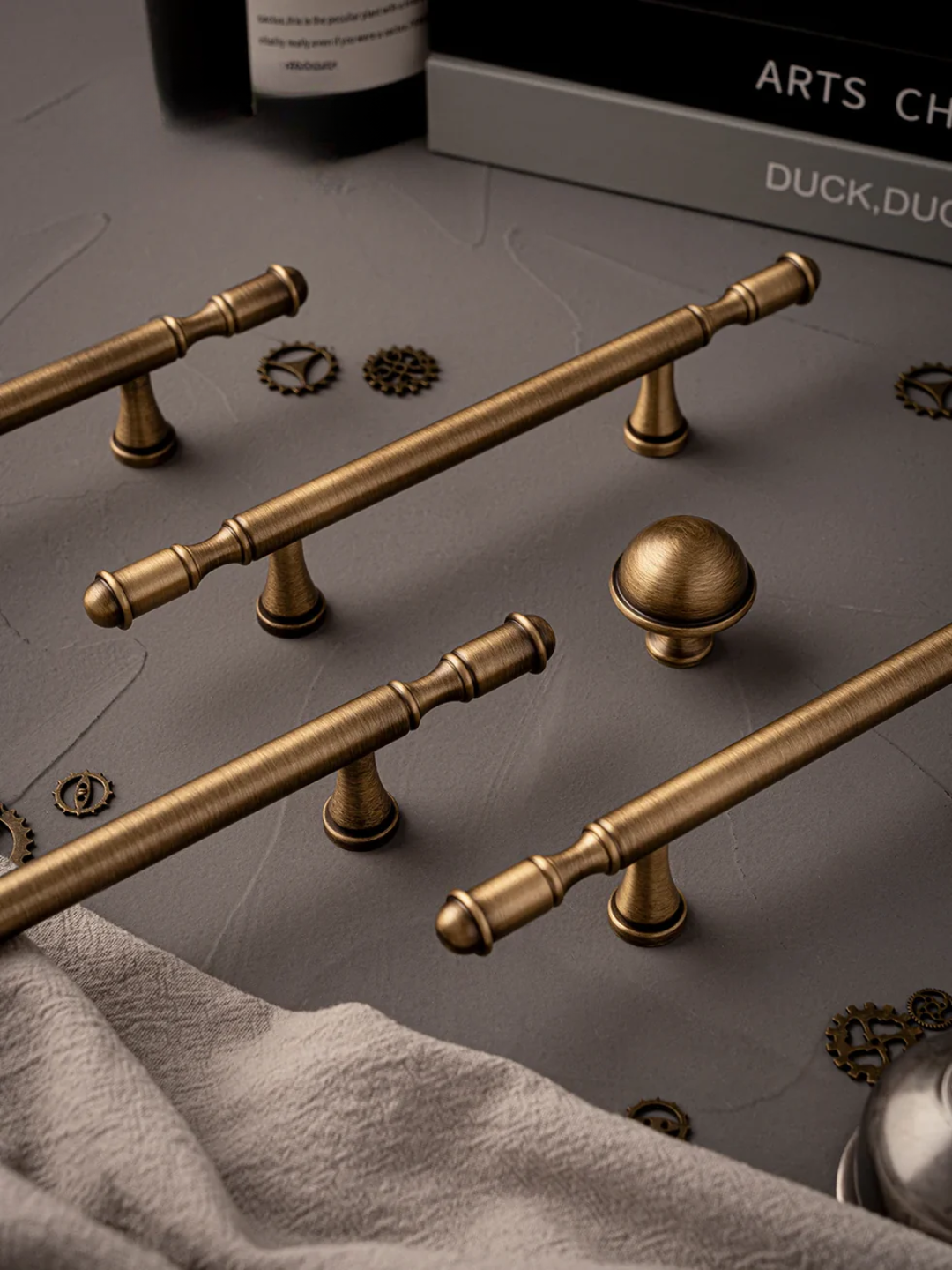 Set of brass cabinet handles and knobs on a gray surface
