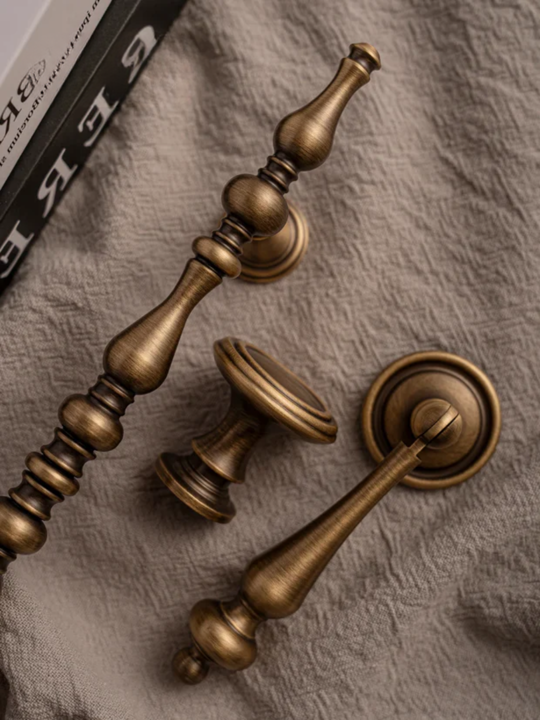 Bronze cabinet handles on a textured fabric background