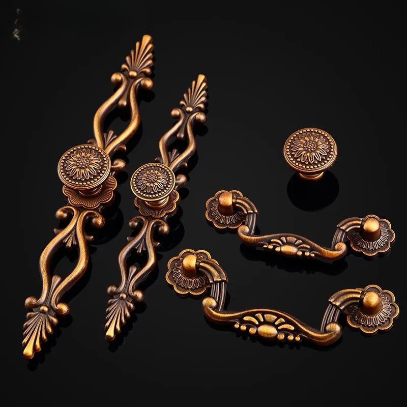 Decorative bronze cabinet handles and knobs on a black background