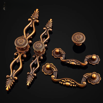 Decorative bronze cabinet handles and knobs on a black background