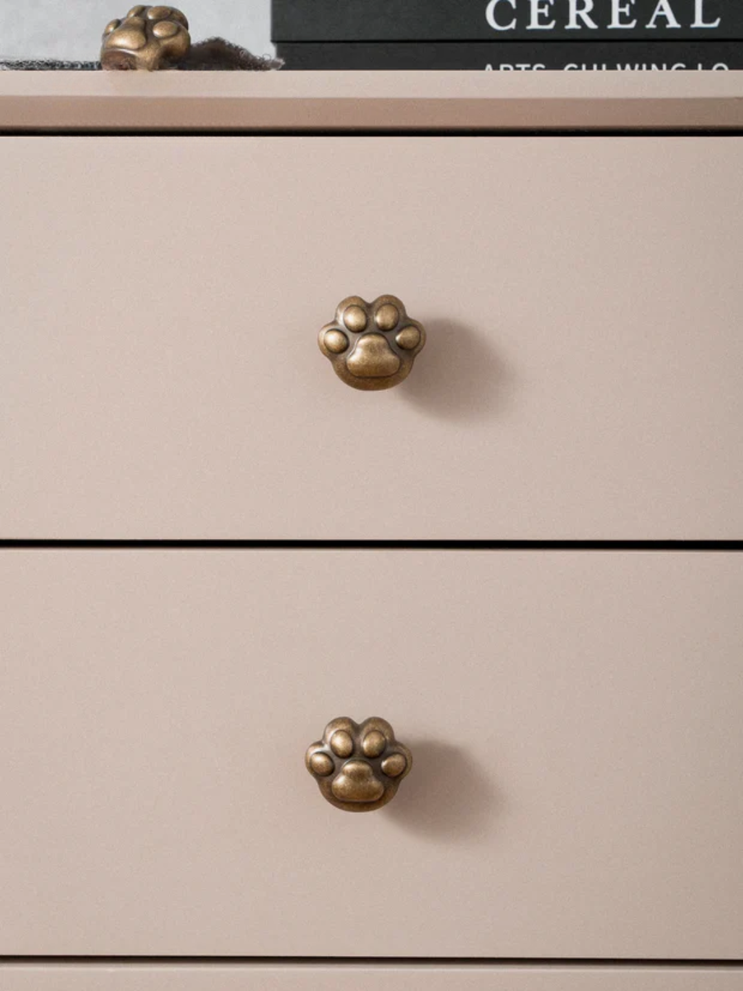 Beige dresser with paw-shaped brass knobs