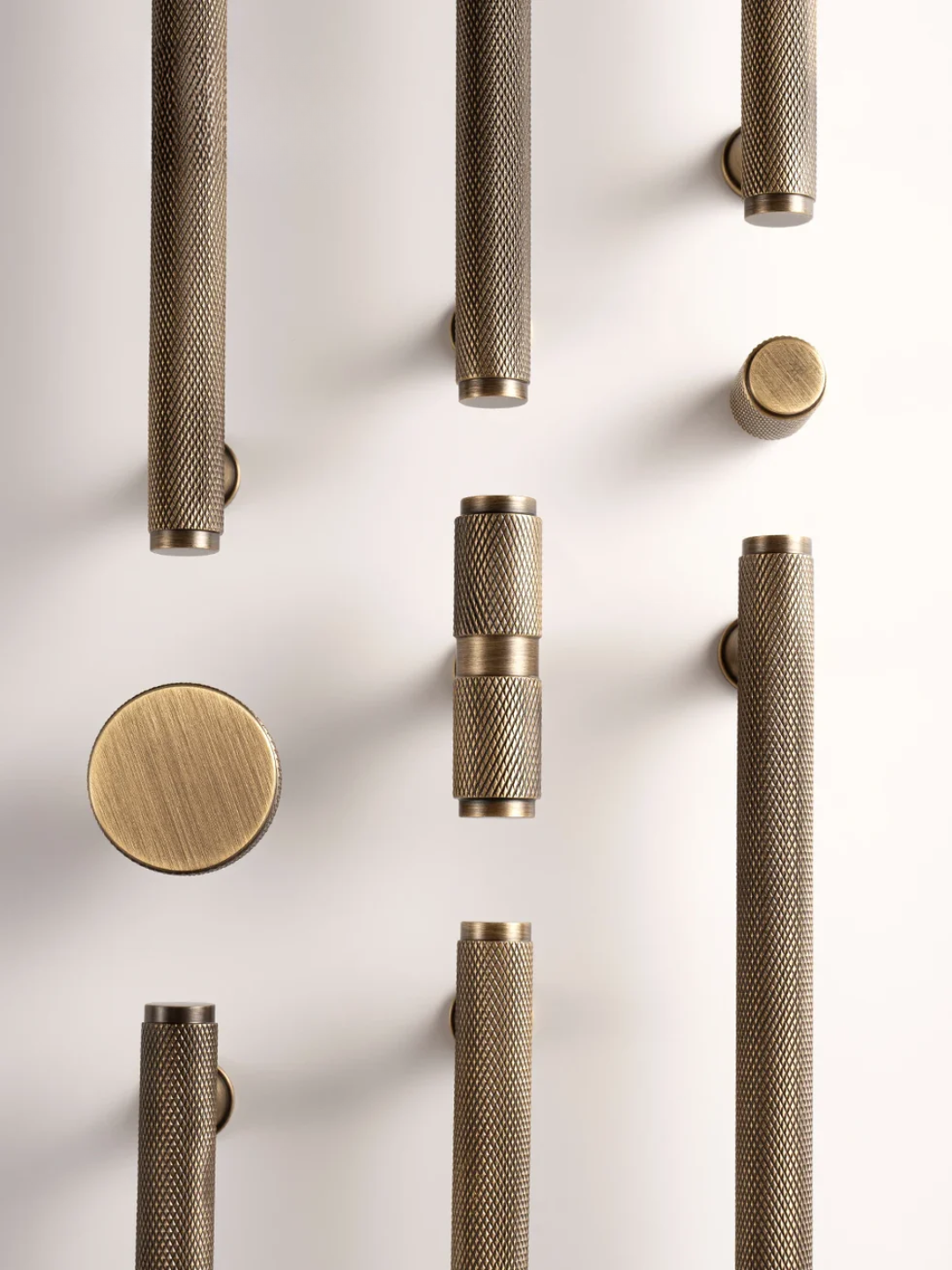 Collection of metallic door handles on a light background
